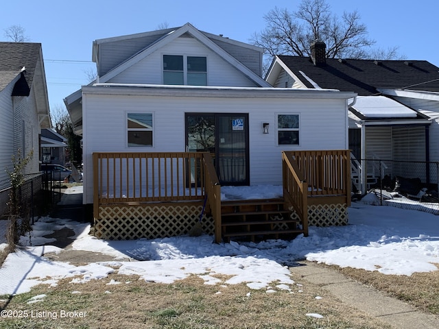 snow covered house featuring a wooden deck