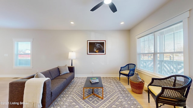 living area with a healthy amount of sunlight, light wood-type flooring, baseboards, and recessed lighting