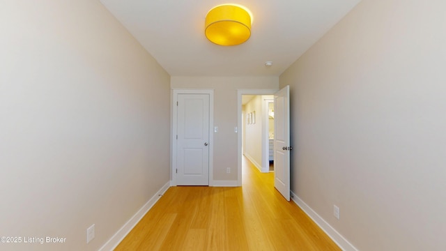 hallway with baseboards and wood finished floors