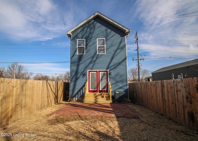 view of front of home with entry steps, a patio, central AC, and a fenced backyard