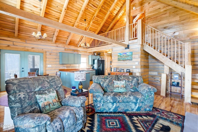 living room featuring wood walls, wood-type flooring, a notable chandelier, wooden ceiling, and beam ceiling