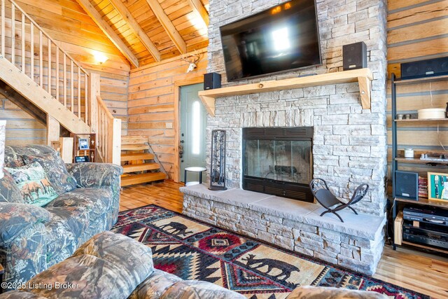 living room featuring vaulted ceiling with beams, wooden ceiling, and wood walls