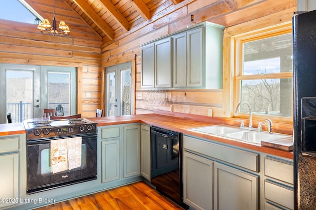 kitchen with sink, hanging light fixtures, black appliances, wood counters, and french doors