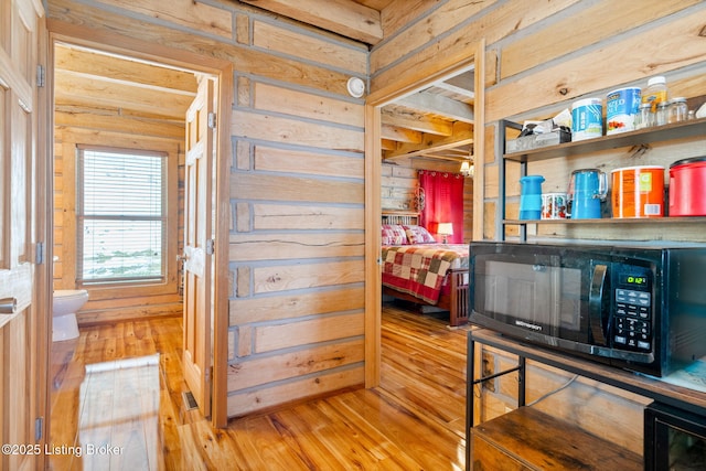 bedroom with hardwood / wood-style floors and wood walls