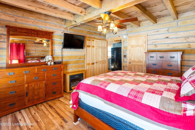 bedroom with wood walls, beamed ceiling, wood ceiling, black fridge with ice dispenser, and light wood-type flooring