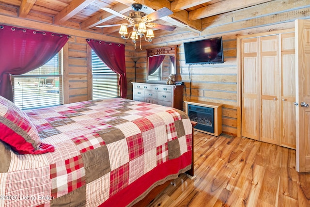 bedroom featuring beamed ceiling, wood-type flooring, wooden ceiling, and wood walls