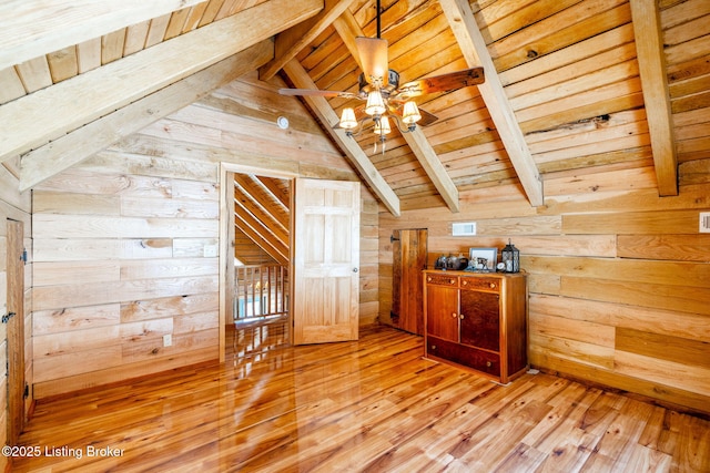 additional living space with vaulted ceiling with beams, wood walls, wooden ceiling, hardwood / wood-style flooring, and ceiling fan