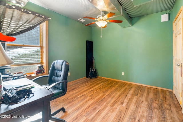 home office with light hardwood / wood-style flooring and ceiling fan