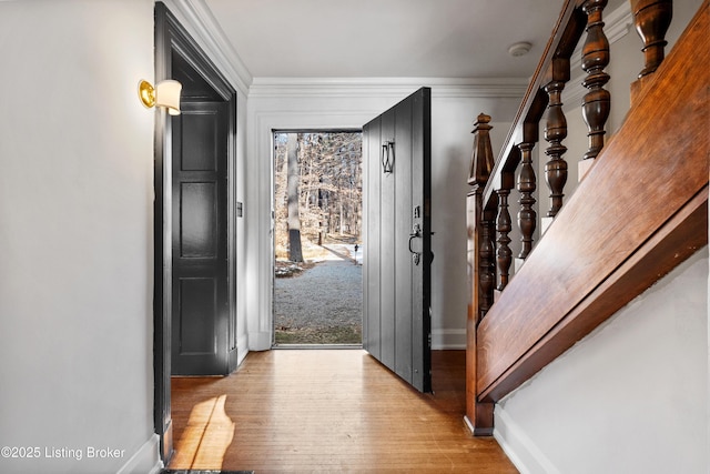 entrance foyer featuring ornamental molding and light hardwood / wood-style flooring