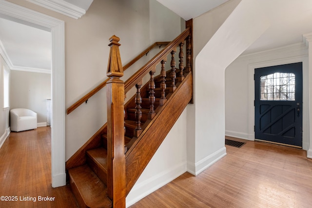 entrance foyer featuring ornamental molding and light hardwood / wood-style floors