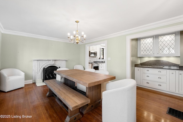 dining room with a notable chandelier, crown molding, and dark hardwood / wood-style floors