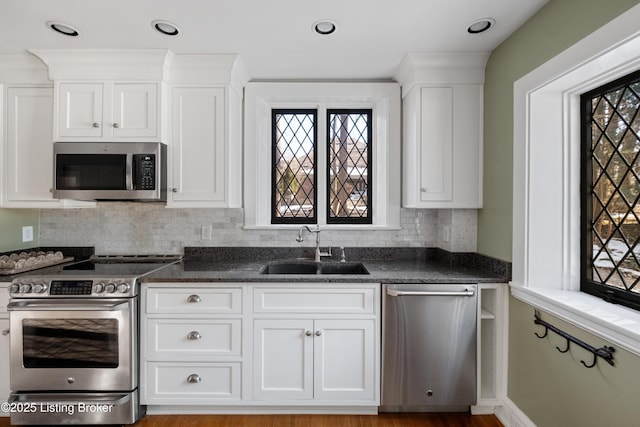 kitchen featuring white cabinetry, sink, dark stone counters, and appliances with stainless steel finishes