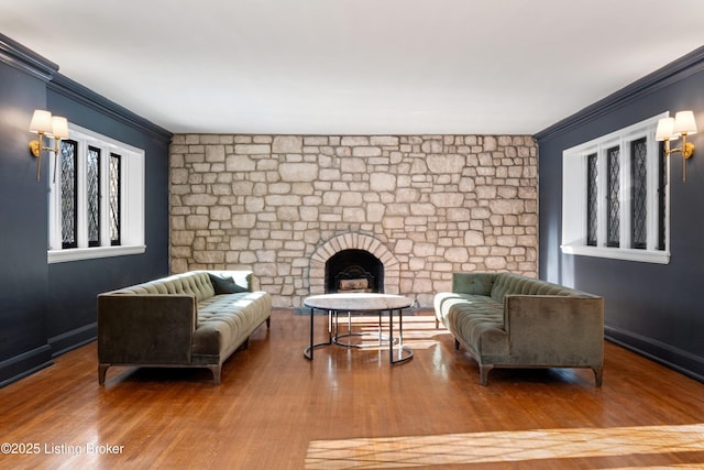 sitting room featuring crown molding, wood-type flooring, and a fireplace