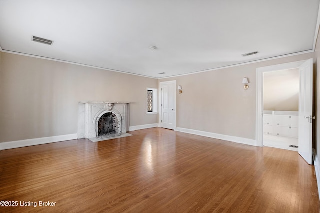 unfurnished living room featuring ornamental molding and hardwood / wood-style floors