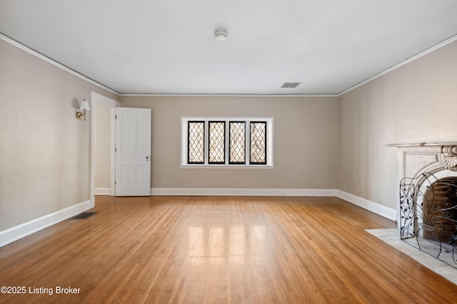 unfurnished living room with ornamental molding and light wood-type flooring