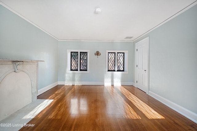 unfurnished living room with a high end fireplace, wood-type flooring, and ornamental molding