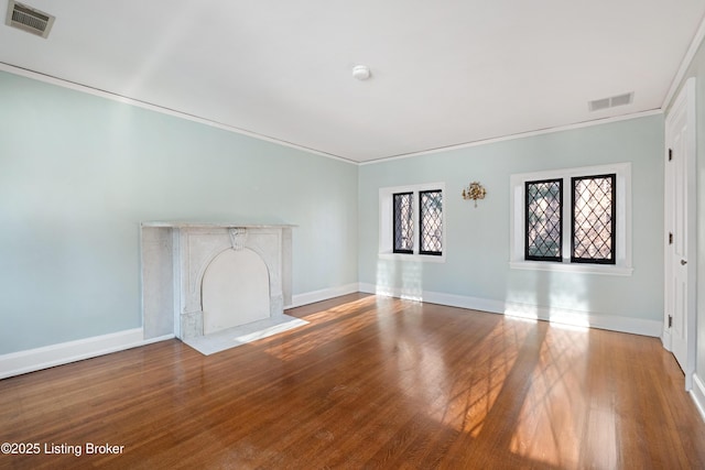 unfurnished living room featuring wood-type flooring and ornamental molding