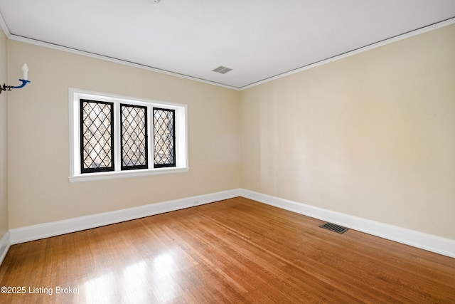 empty room featuring hardwood / wood-style floors and ornamental molding