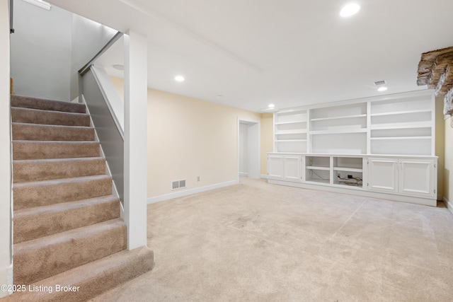 unfurnished living room with carpet floors and built in features