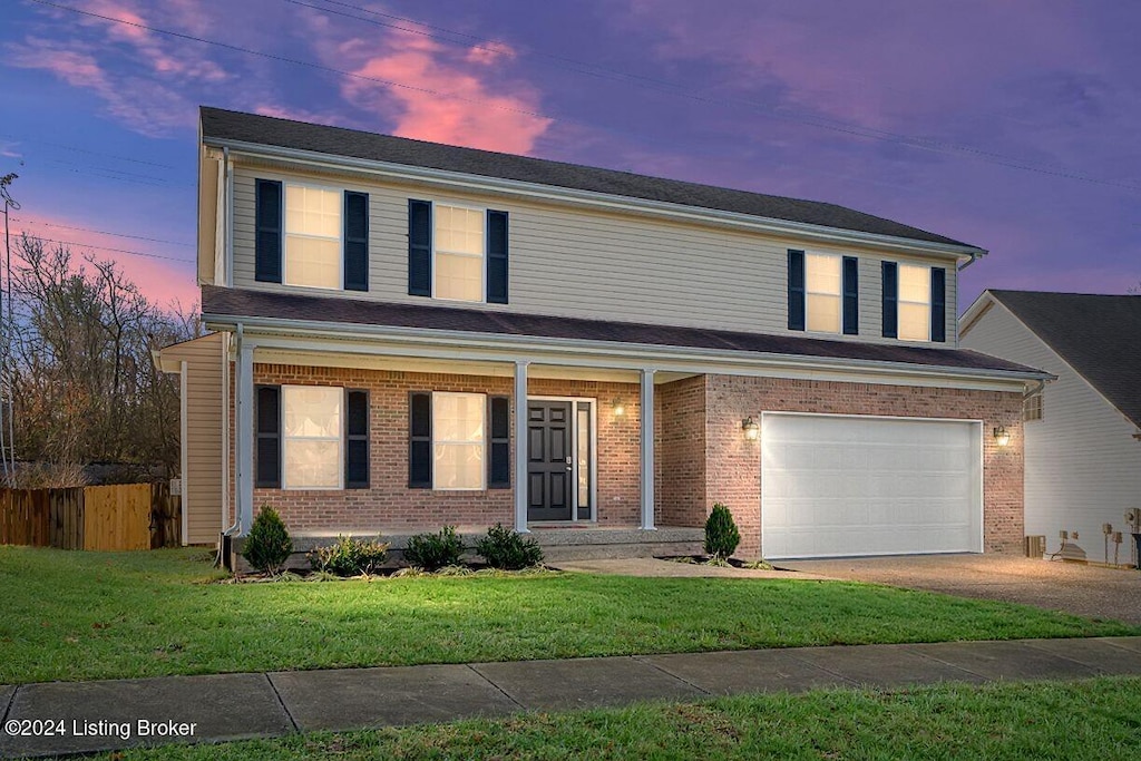 front of property with a garage and a yard