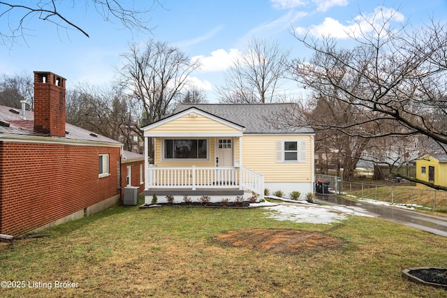 bungalow-style house with a porch, central AC unit, and a front yard