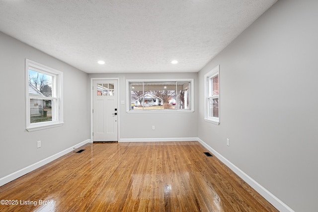 foyer with a textured ceiling and light wood-type flooring