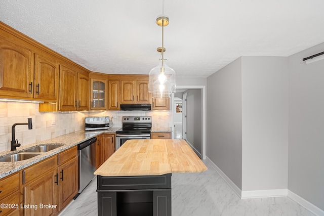 kitchen featuring a kitchen island, wood counters, sink, decorative backsplash, and stainless steel appliances