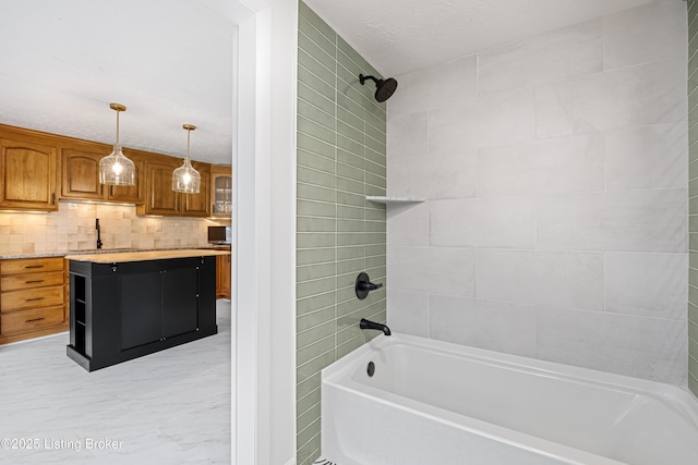 bathroom with tasteful backsplash, tiled shower / bath, and vanity