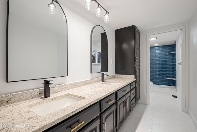 bathroom featuring vanity, toilet, tile patterned flooring, and a tile shower