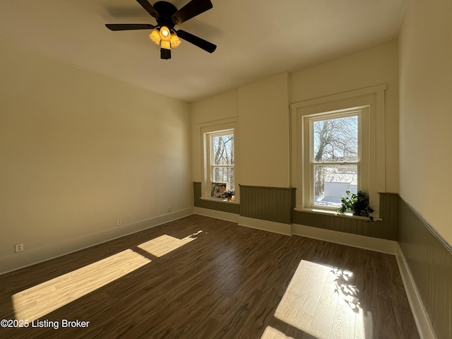 empty room with dark hardwood / wood-style floors and ceiling fan