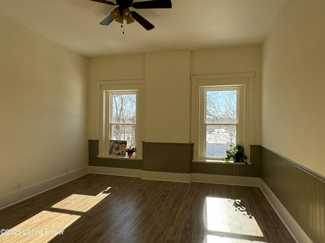 unfurnished room featuring dark wood-type flooring and ceiling fan