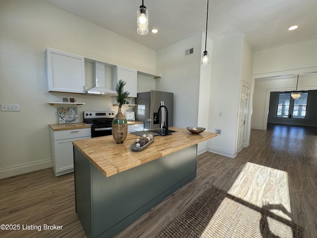 kitchen with white cabinetry, butcher block counters, sink, stainless steel appliances, and wall chimney exhaust hood