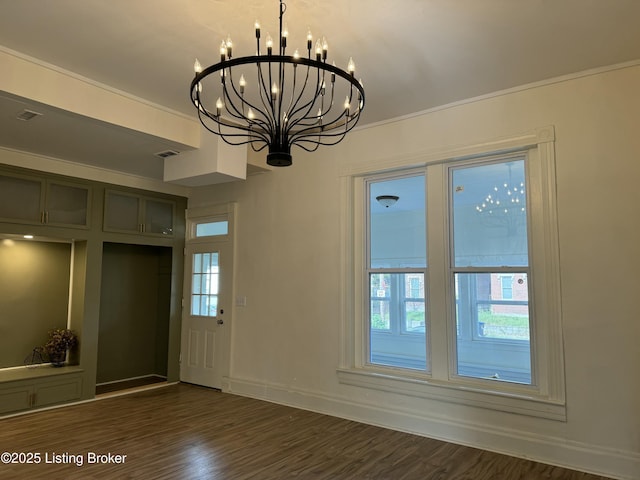 interior space featuring crown molding, a notable chandelier, and dark hardwood / wood-style flooring