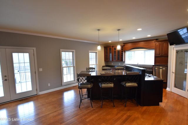 kitchen with crown molding, a wealth of natural light, a breakfast bar, and a kitchen island