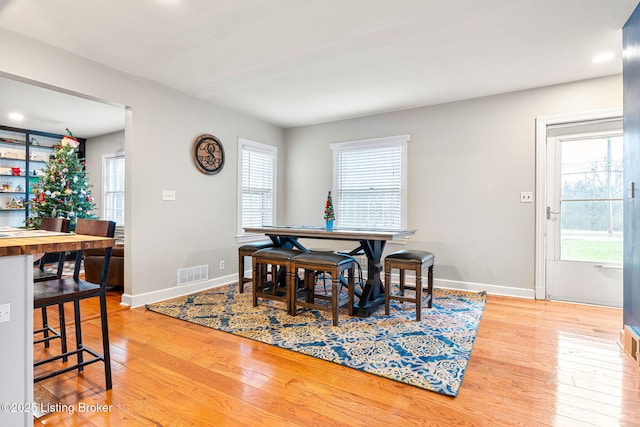 dining room featuring wood-type flooring and a wealth of natural light