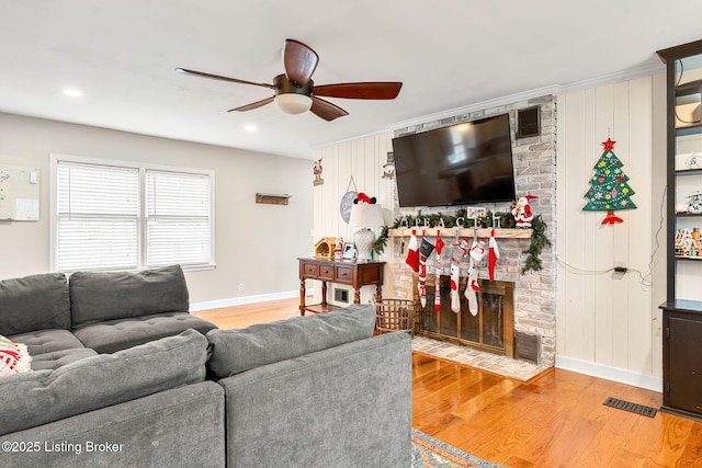 living room with hardwood / wood-style floors, ornamental molding, and ceiling fan