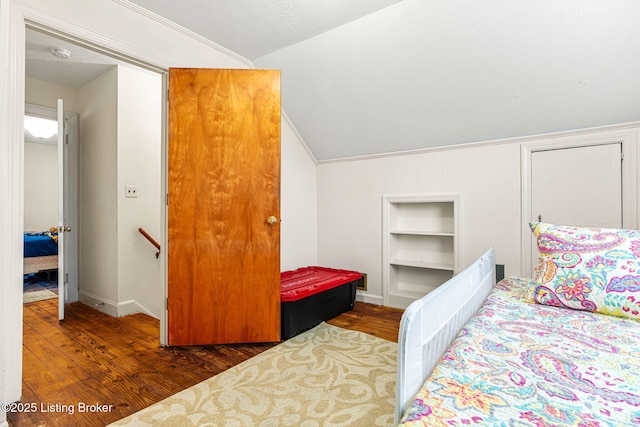 bedroom featuring dark wood-type flooring, lofted ceiling, and a textured ceiling