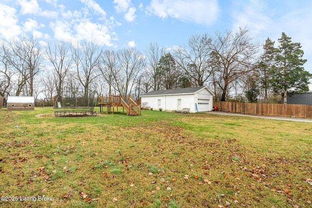 view of yard featuring a garage and an outbuilding