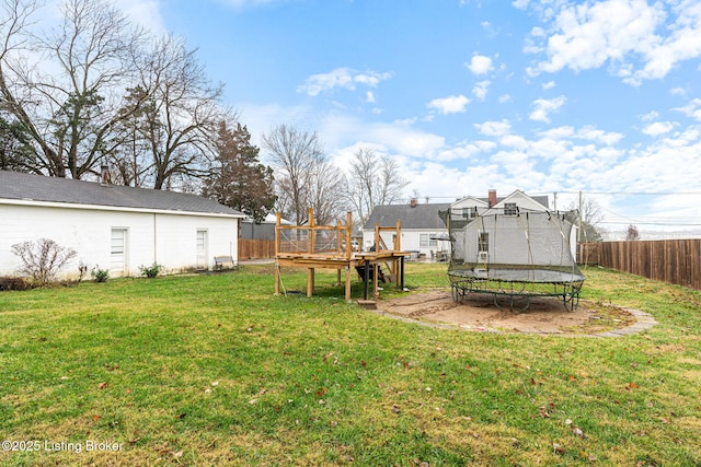 view of yard featuring a wooden deck and a trampoline