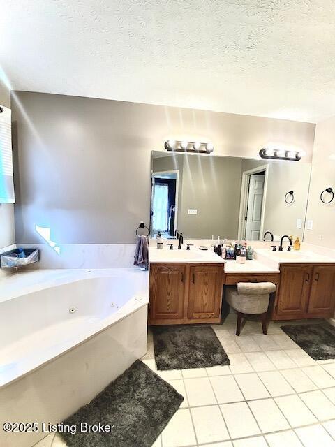 bathroom with tile patterned flooring, vanity, and a textured ceiling