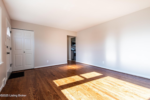 spare room with dark wood-type flooring