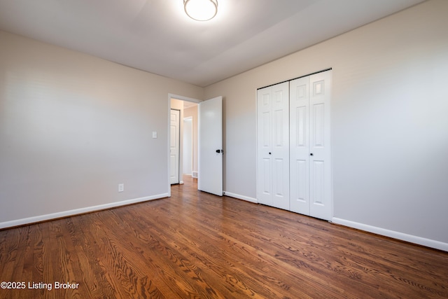 unfurnished bedroom featuring dark hardwood / wood-style flooring and a closet