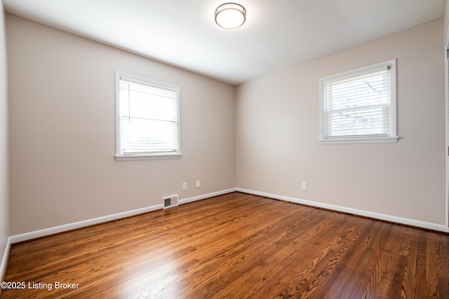 spare room with dark hardwood / wood-style flooring