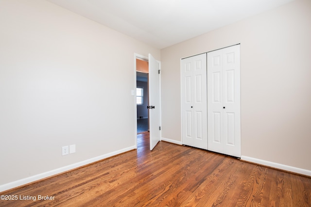 unfurnished bedroom featuring dark hardwood / wood-style flooring and a closet