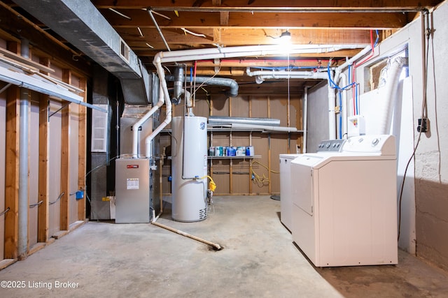 basement with water heater, heating unit, and independent washer and dryer