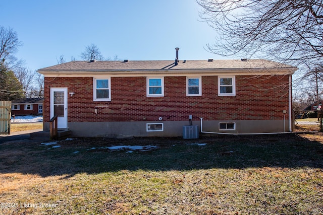 rear view of property featuring a lawn and central air condition unit