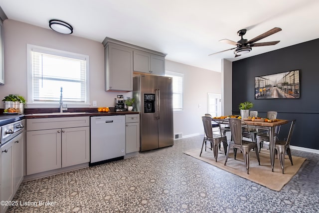 kitchen with sink, gray cabinetry, ceiling fan, white dishwasher, and stainless steel refrigerator with ice dispenser