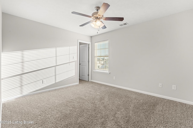 spare room with carpet, visible vents, ceiling fan, and baseboards