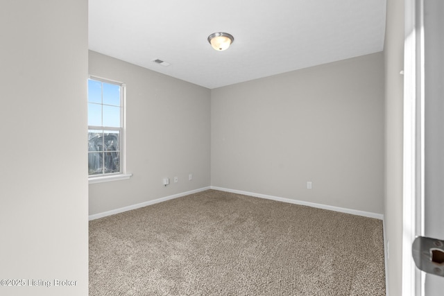 carpeted spare room with visible vents and baseboards