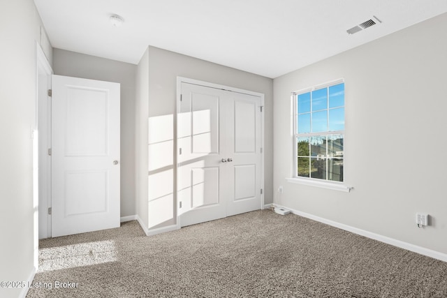 unfurnished bedroom with carpet floors, visible vents, and baseboards